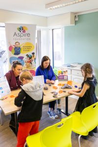 Aspire UK hosting a stall with children making shapes out of clay